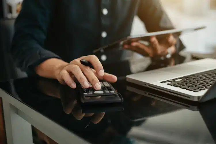 Accountant working at his desk with a laptop and calculator.