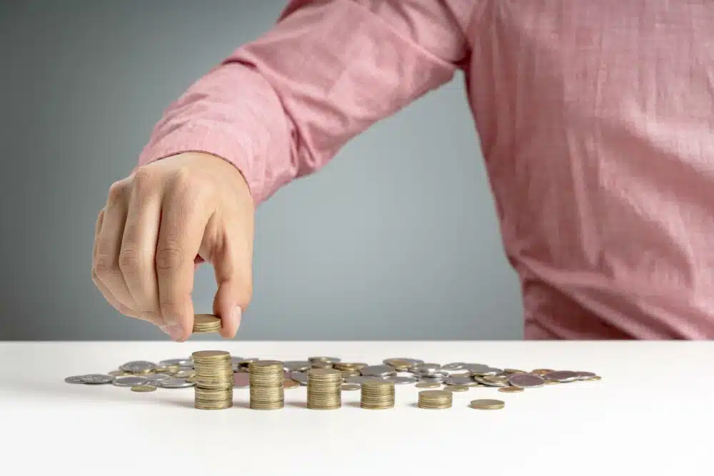 a man stacking a pile of coins