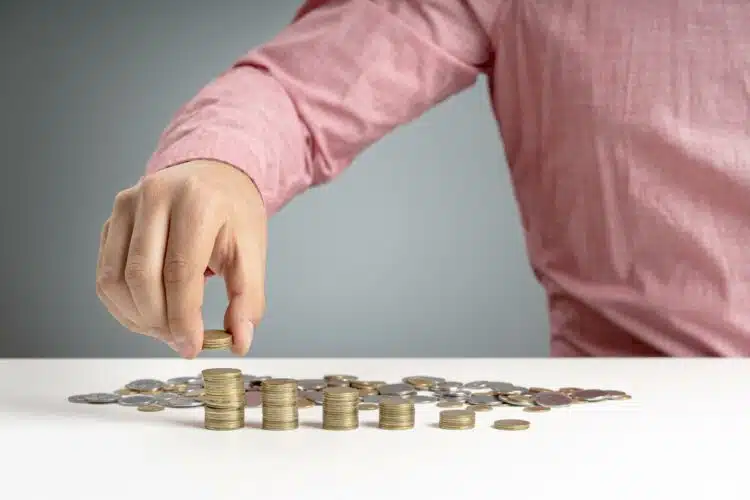 a man stacking a pile of coins