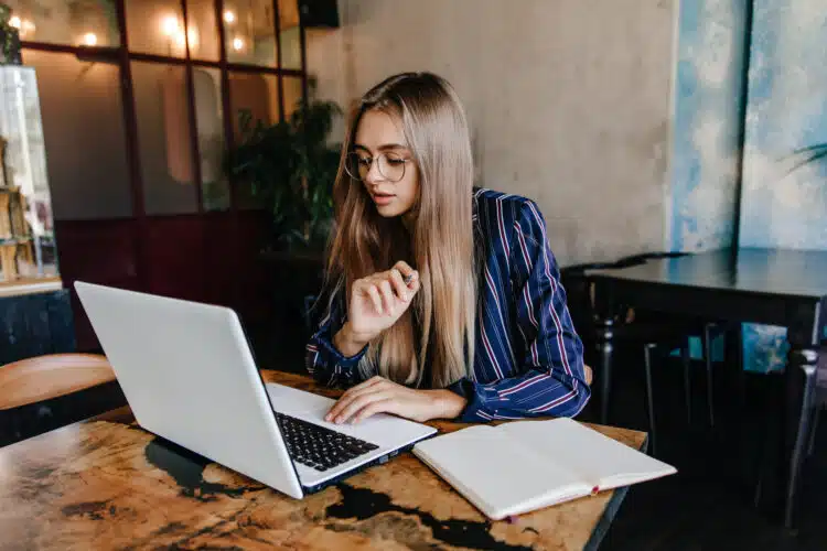 Concentrated young woman working on laptop