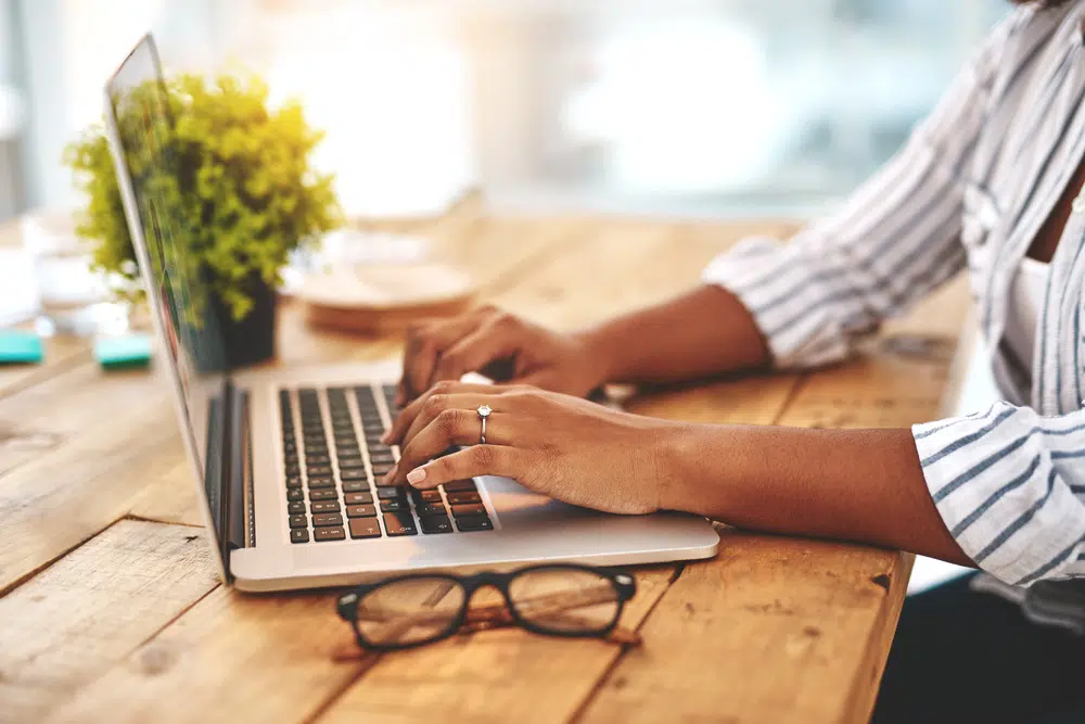 a woman typing on a laptop